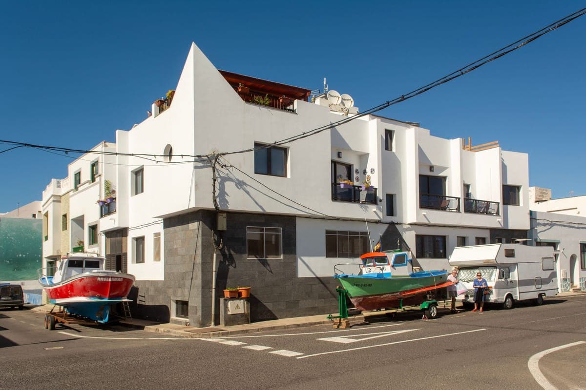 Fishing boats on trailers beside white houses in El Cotillo