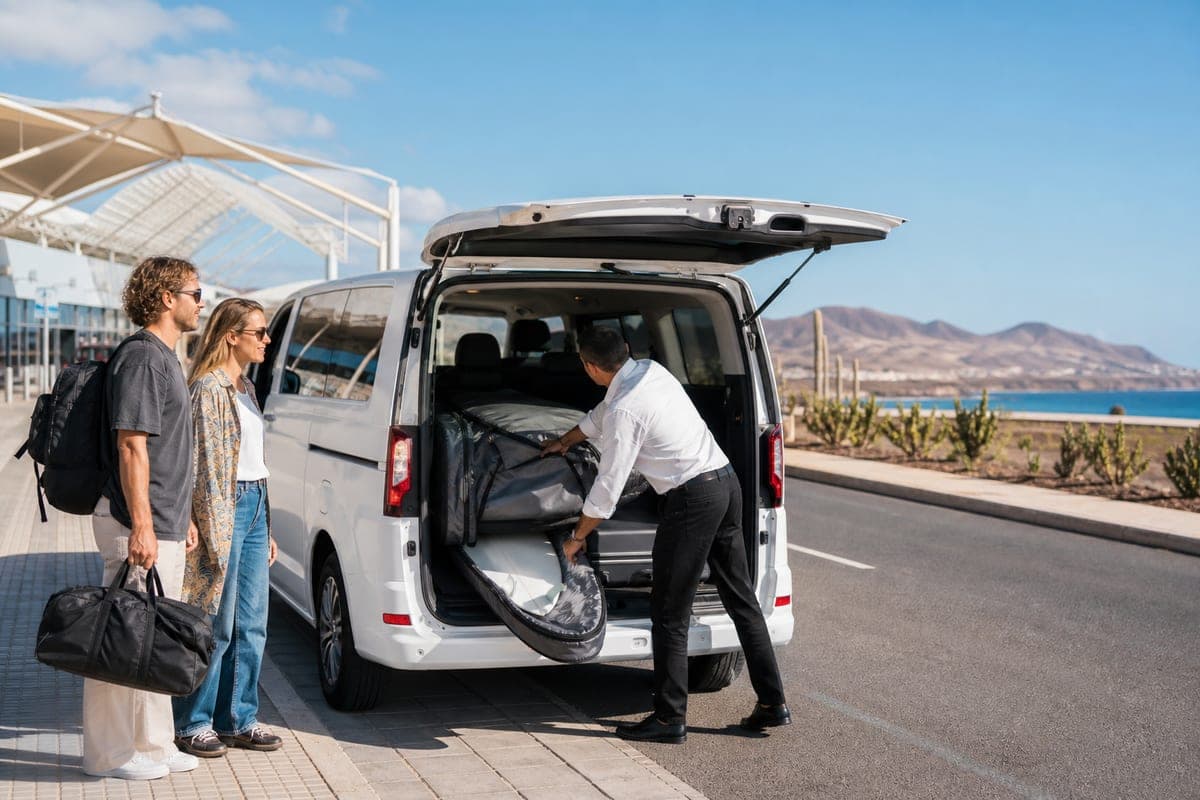Driver loading surf equipment into a private transfer van in Fuerteventura